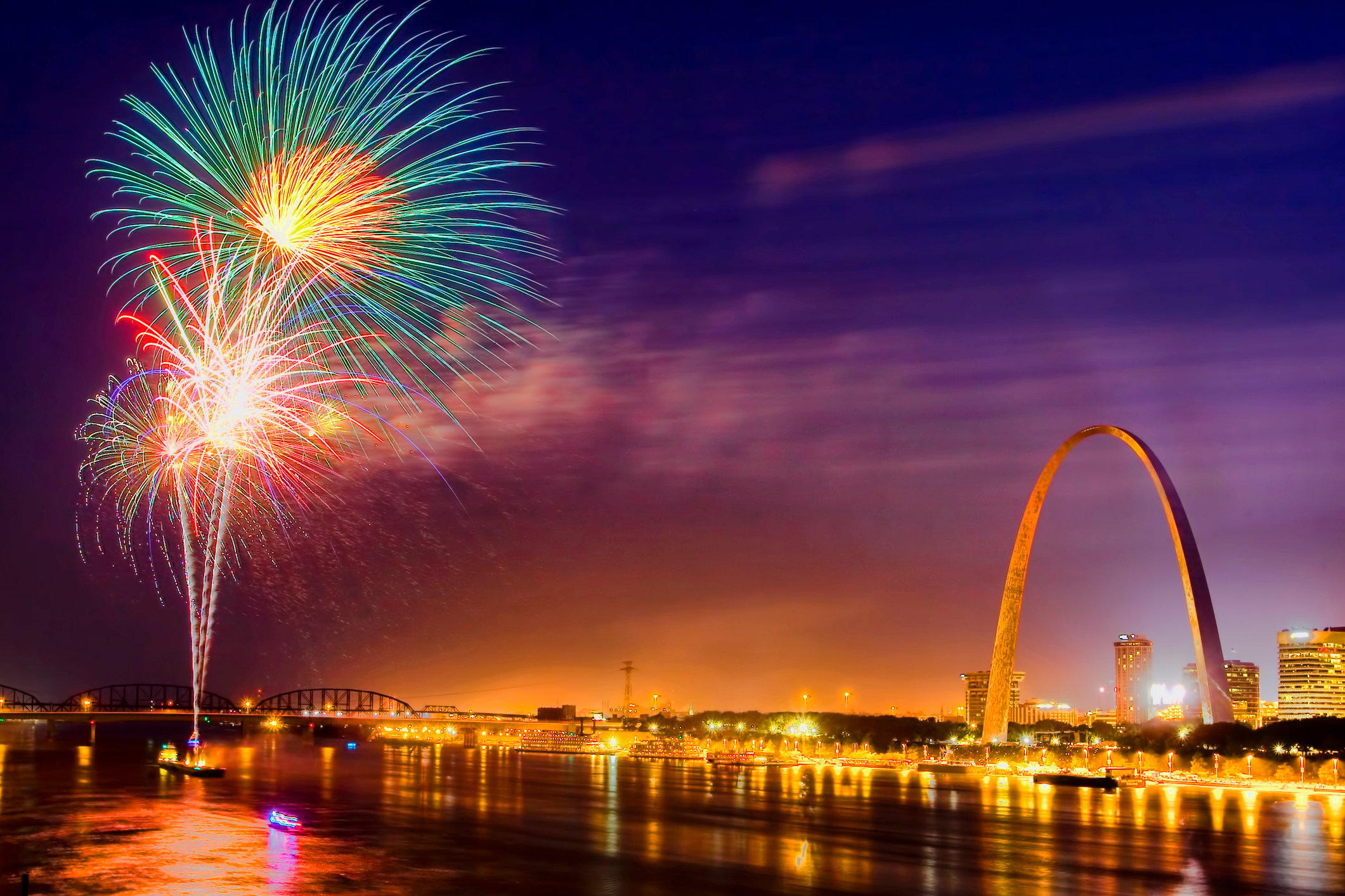 Fireworks on the Mississippi River at night with the Arch in the background