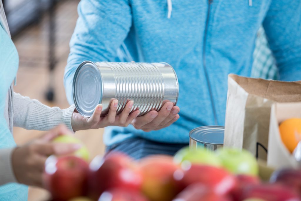 Volunteers organize fruit and canned food at food bank.