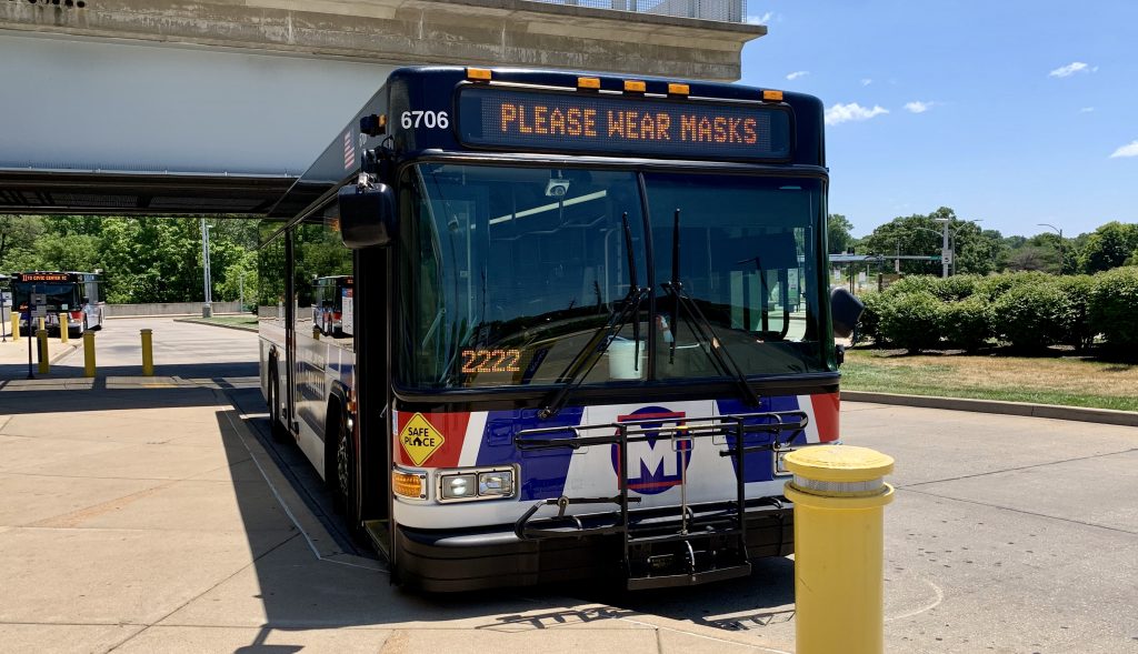 Image of the front of a MetroBus with the headsign reading "Please wear masks"