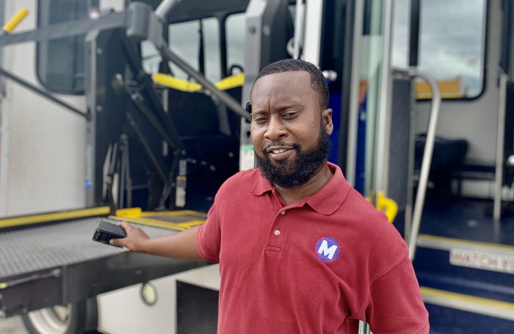Image of Everett McKenzie, Call-A-Ride Operator, standing in front of a Call-A-Ride van. 