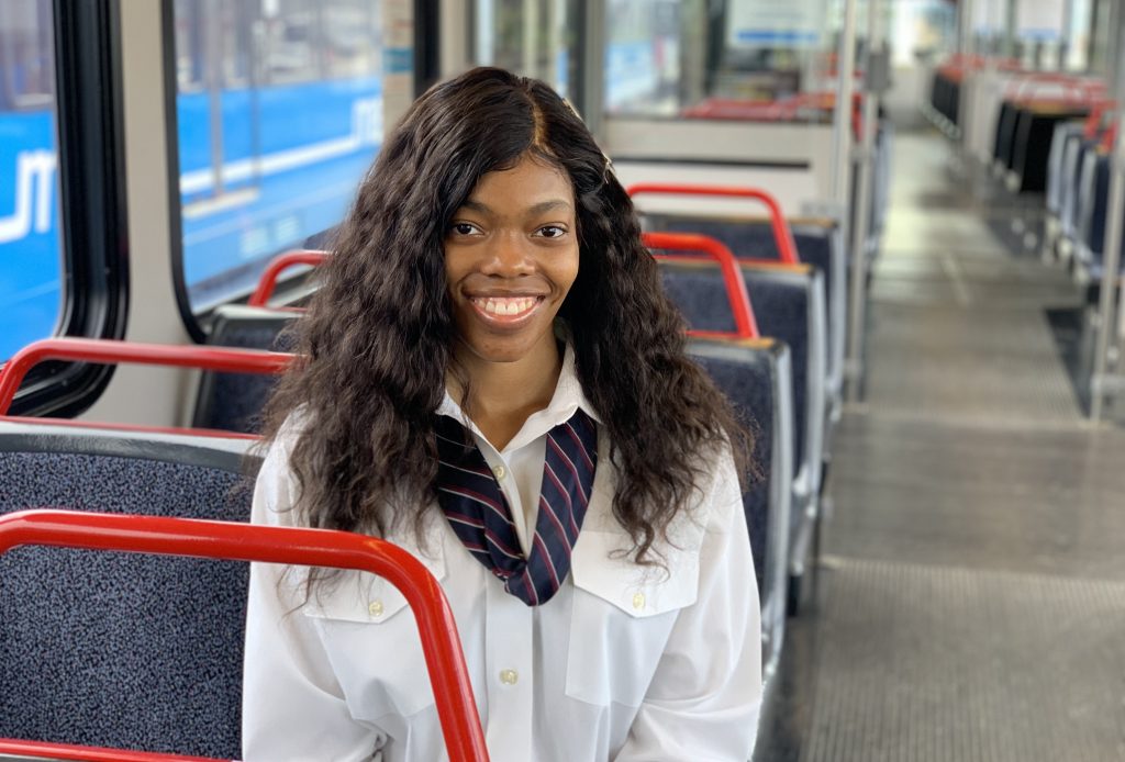 Image of Shaftia, MetroLink Operator, standing sitting on a train, smiling at the camera. 