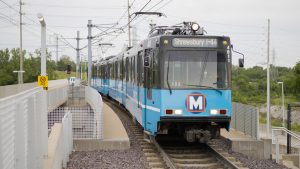 A MetroLink train approaches the Shewsbury-Lansdowne I-44 station. the operator can be seen through the windshield.