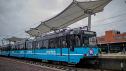 A MetroLink train stops at the Cortex MetroLink station. The platform canopies appear in the background.