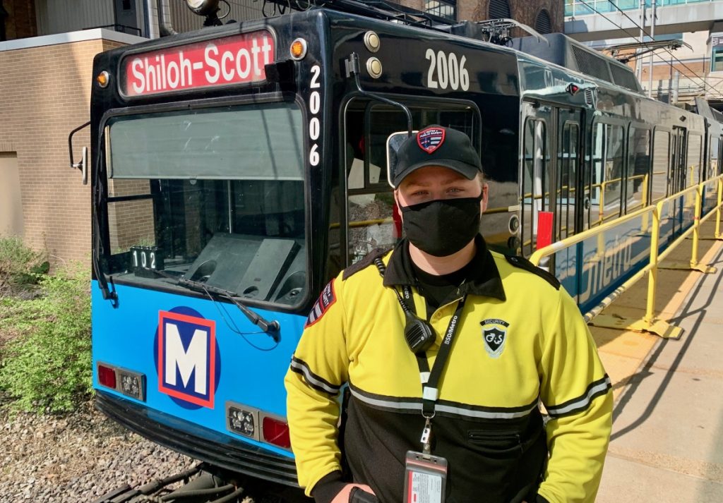 G4S Team Member Skye standing on a MetroLink platform with a train behind them