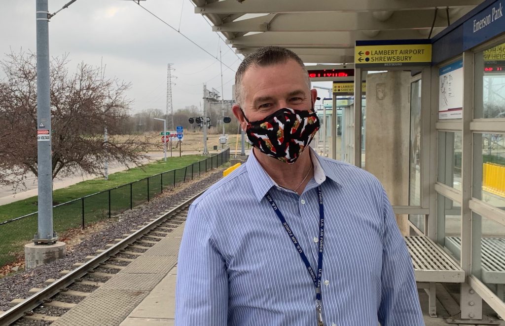 Passenger Doug standing on the Emerson Park MetroLink Station platform, smiling at the camera and wearing a face mask