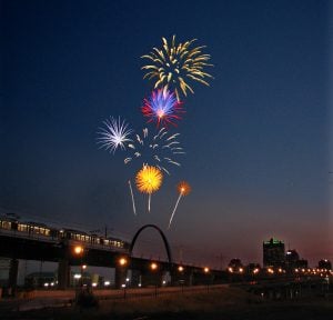MetroLink train on Eads Bridge with fireworks over the Arch