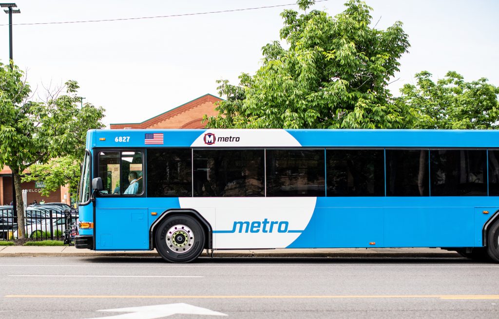 A MetroBus pulls up to a bus stop in front of the Clayton Rd. Schnucks.