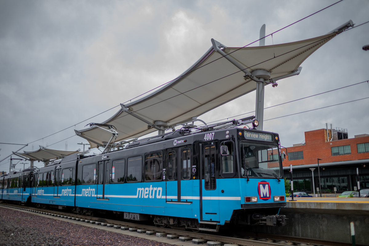 A MetroLink train stops at the Cortex MetroLink station. The platform canopies appear in the background.