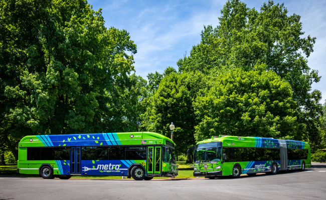 60-foot and 40-foot electric buses on the street with trees behind them