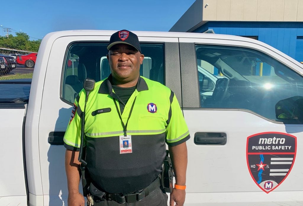 Photo of Public Safety team member Tyjuan standing in front of a Public Safety vehicle
