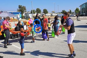 Photo from MetroFest: Child and juggler passing hoops back and forth at MetroFest with the festival in the background