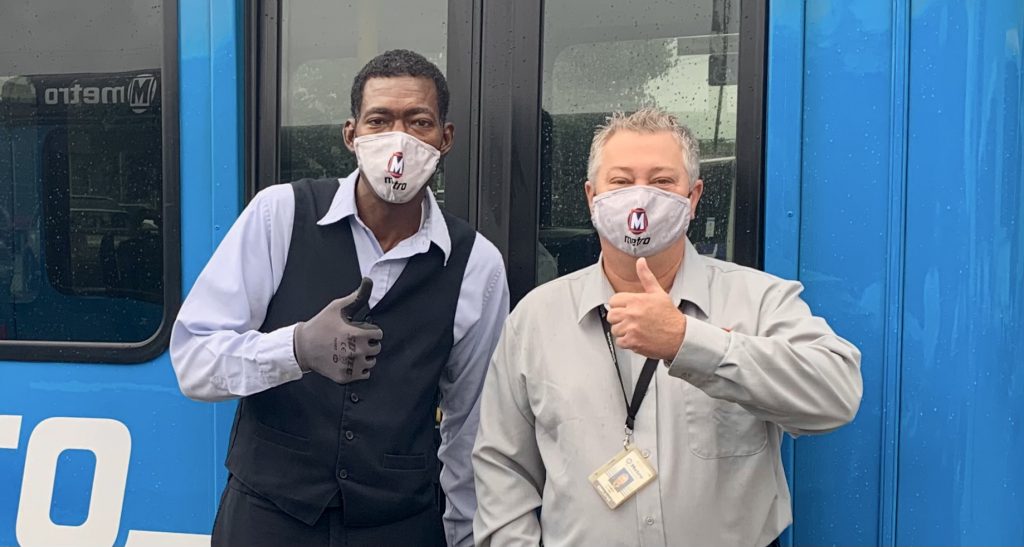 Metro Call-A-Ride Operators of the Year, Jerome and James, standing in front of a Call-A-Ride van giving a thumbs up