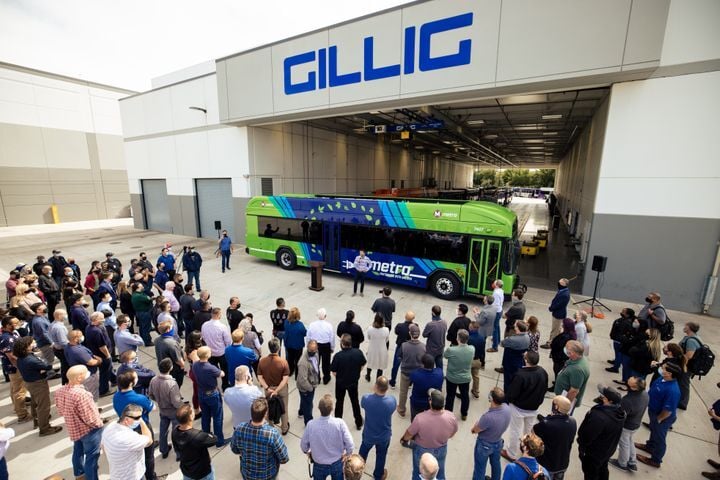 Photo of Gillig's 100th battery electric bus outside of its facility, with a group of people in front of it