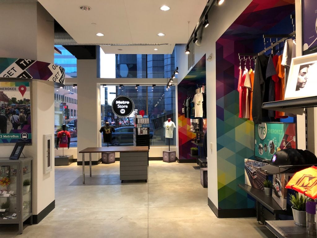 Interior shot of the MetroStore. Display alcoves with t-shirts and merchandise appear on the right. In the background, the streets of Downtown St. Louis can be seen through the store windows.