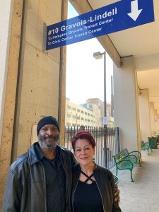 Kenneth and Michelle photo standing below a #10 bus stop sign