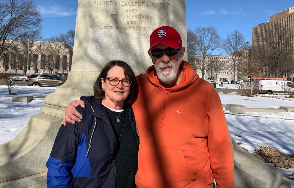 Photo of Joel and Len smiling in front of a park