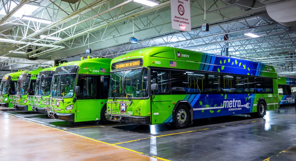 3/4 shot of the fronts and sides of an electric bus and articulated electric buses lined up in the Brentwood Garage.