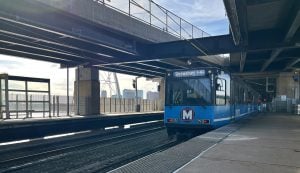 MetroLink train departing from the East Riverfront Station with the Arch showing in the background