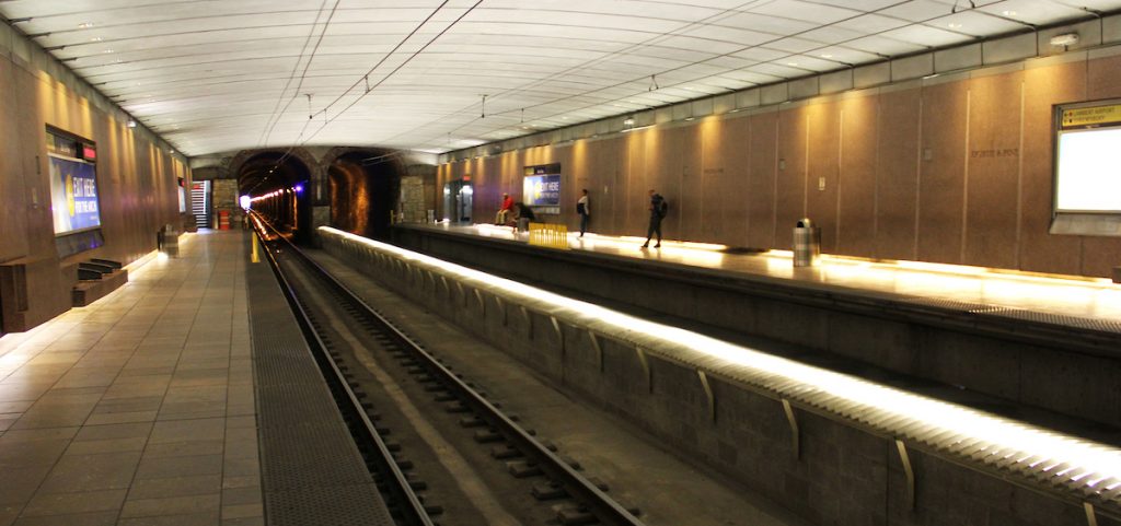 Platform at 8th and Pine MetroLink Station with a few passengers waiting for a train to arrive