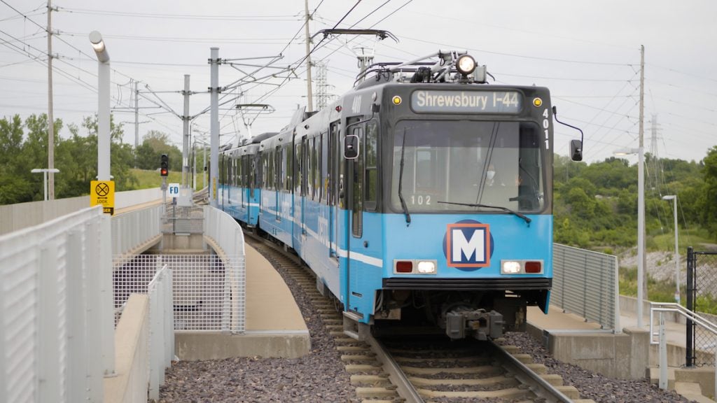 A MetroLink train approaches the Shewsbury-Lansdowne I-44 station. the operator can be seen through the windshield.