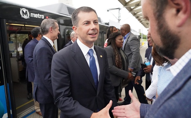 U.S. Secretary of Transportation Pete Buttigieg exits a MetroLink train to greet visitors at the Emerson Park MetroLink Station