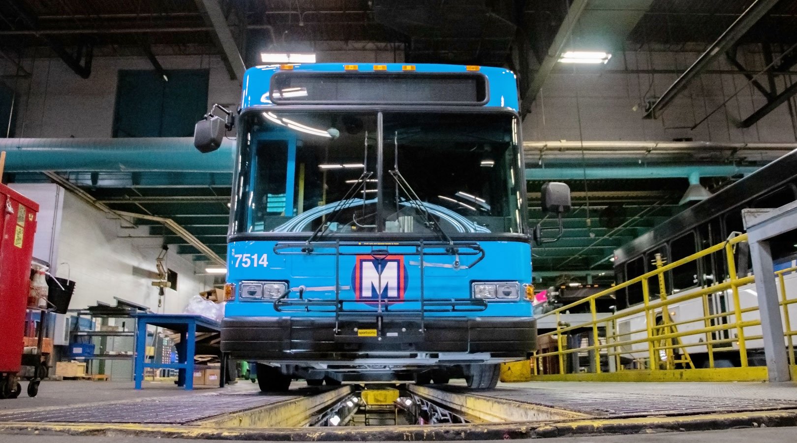 Front view of a Blue MetroBus parked in a service bay inside a Metro maintenance garage